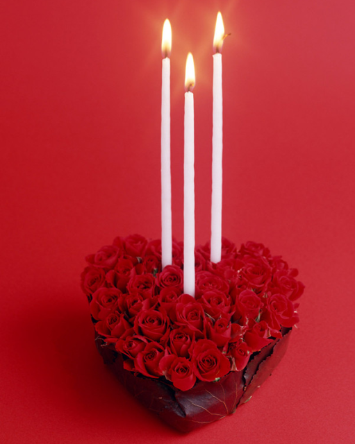 Trendy heart shaped roses valentine arrangement with white long thin candles.PNG
