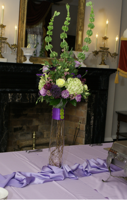 Picture of tall wedding centerpieces with purple and white flowers.PNG