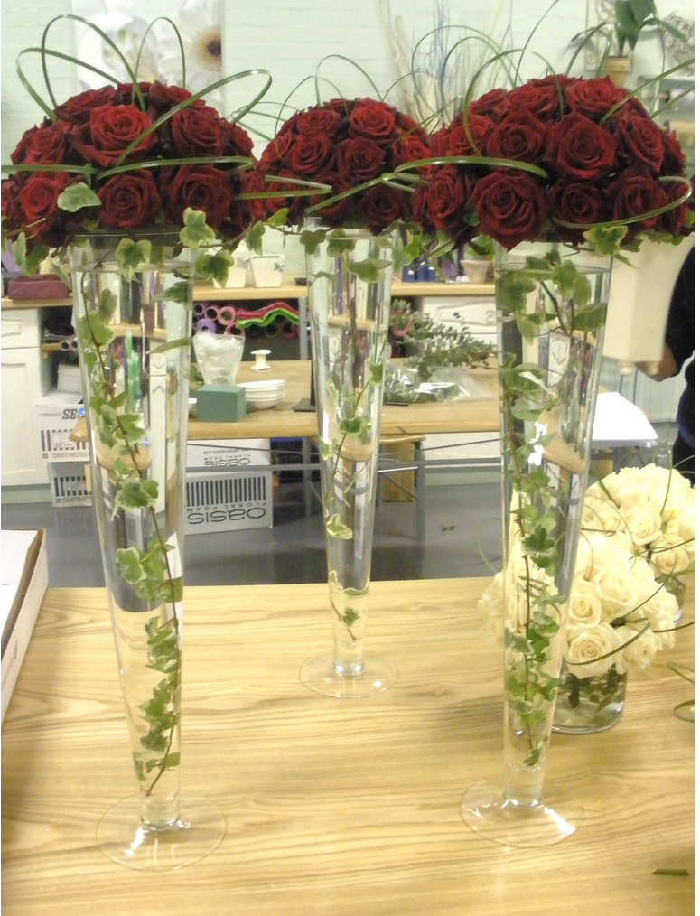 Wedding reception table arrangement with red roses.PNG