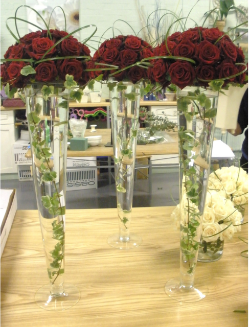 Wedding reception table arrangement with red roses.PNG