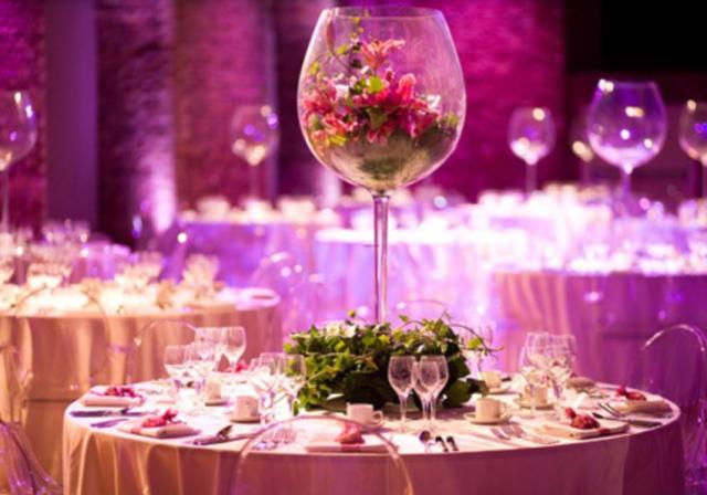 Large wine glass vase with flowers inside the vases.JPG