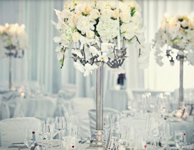 Wedding reception centerpices with white cream flowers and silver stands.JPG