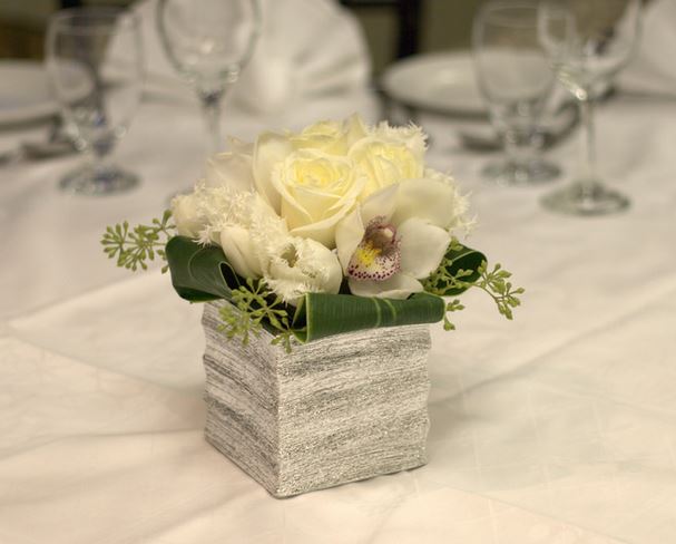 Unique wedding centerpiece with white flowers in  rock vase