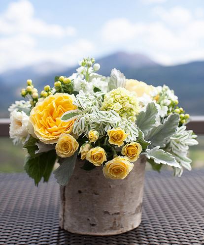 wedding arangement with white flowers and yellow flowers in tree vase