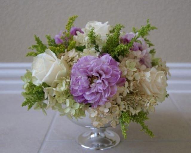 Elegant wedding arrangement flowers with white and purple flowers in silver vase
