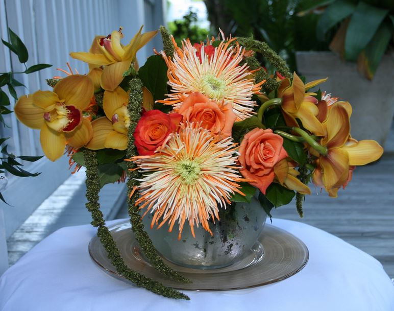 Elegant wedding centerpiece with orange flowers in silver vase