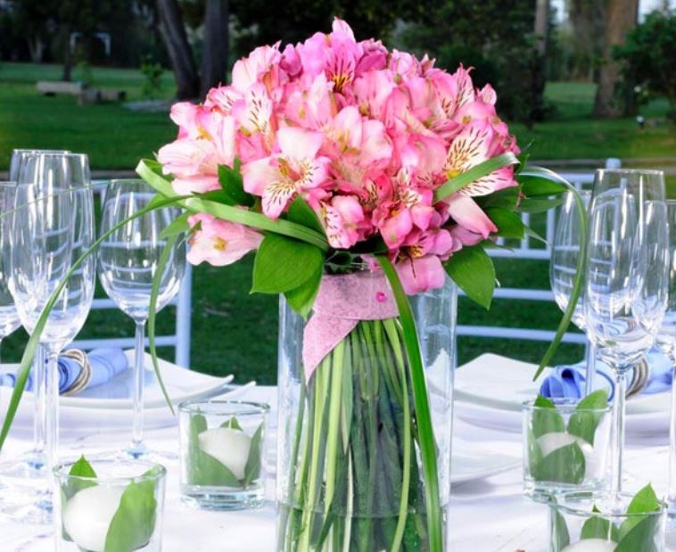 Beautiful wedding centerpieces with pink flowers in tall glass vase