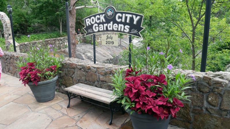 Rock City Gardens Sign Behind Bench with Red Flower Planters