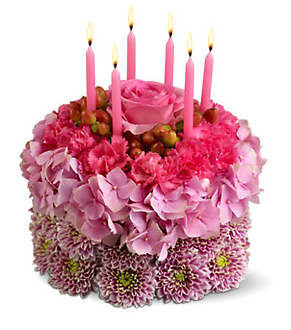 Pink fresh flowers cake shape with pink candels.PNG