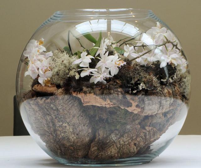 Round glass arrangement with small white flowers and wood pict.JPG